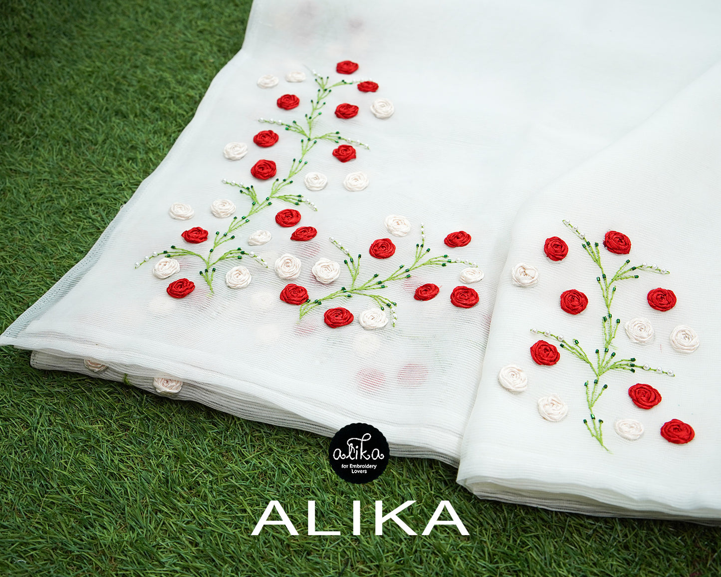 "Elegant White Kota Saree with Ribbon Embroidery Bunches - Adorned with White and Red Floral Accents"
