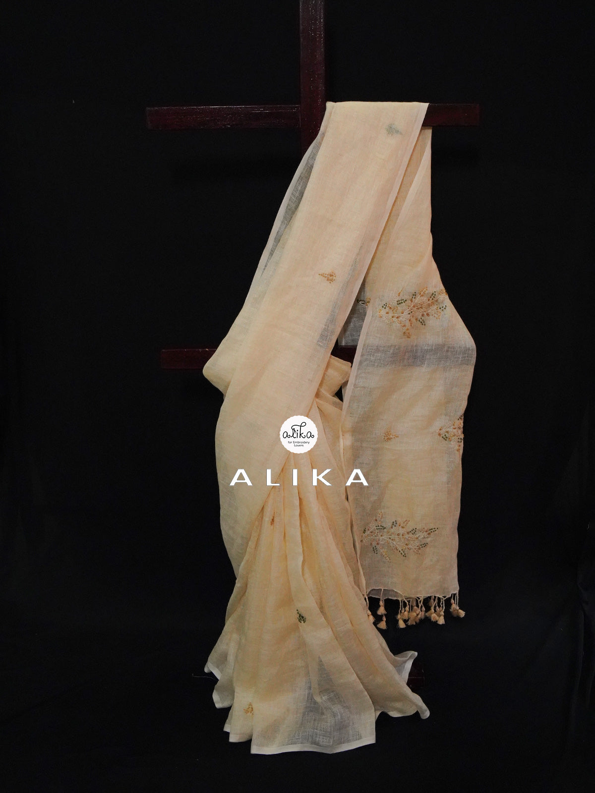 Cream shade linen drape with scattered floral bunches in pallu and small buttas across body
