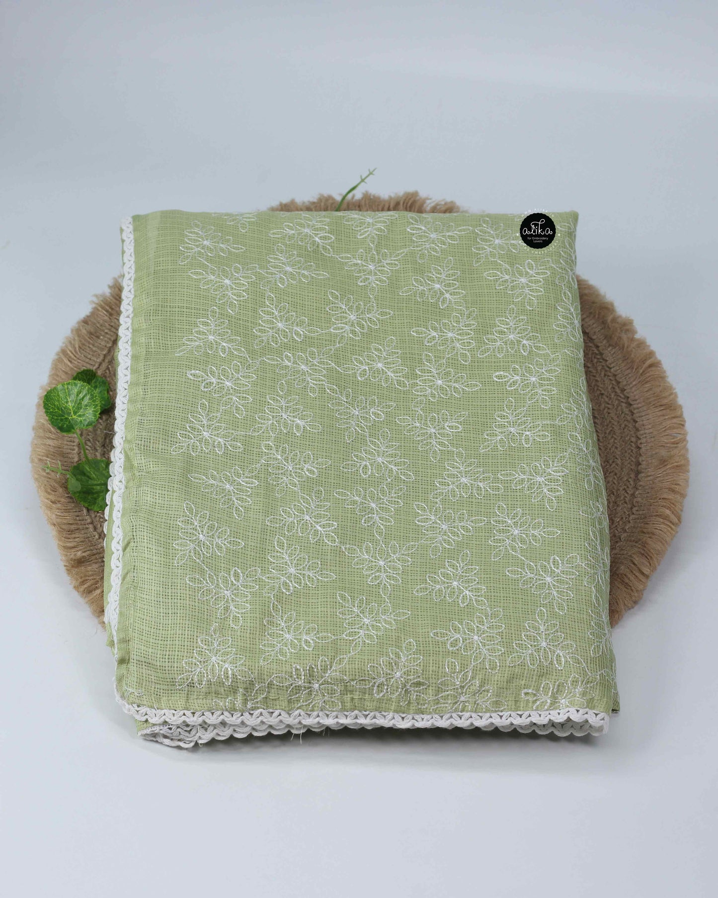 pastel green silky kota saree with floral machine embroidery and lace work