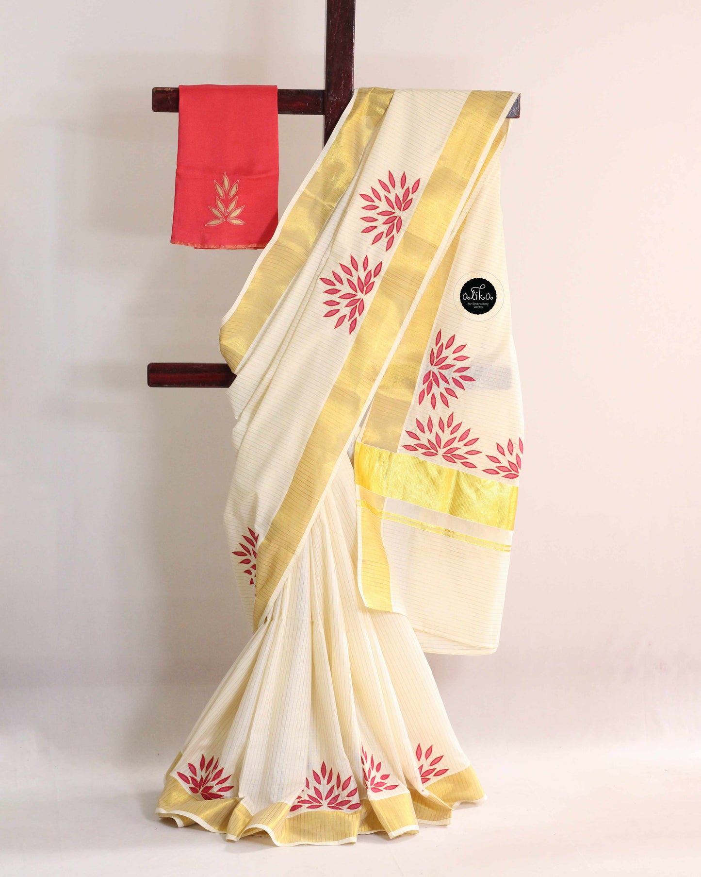 Kerala kasavu saree with floral applique work and contrast blouse piece
