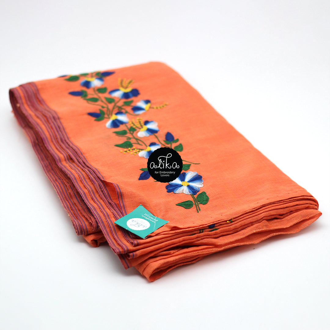 Orange chanderi silk saree with scattered blue floral hand embroidery bunches